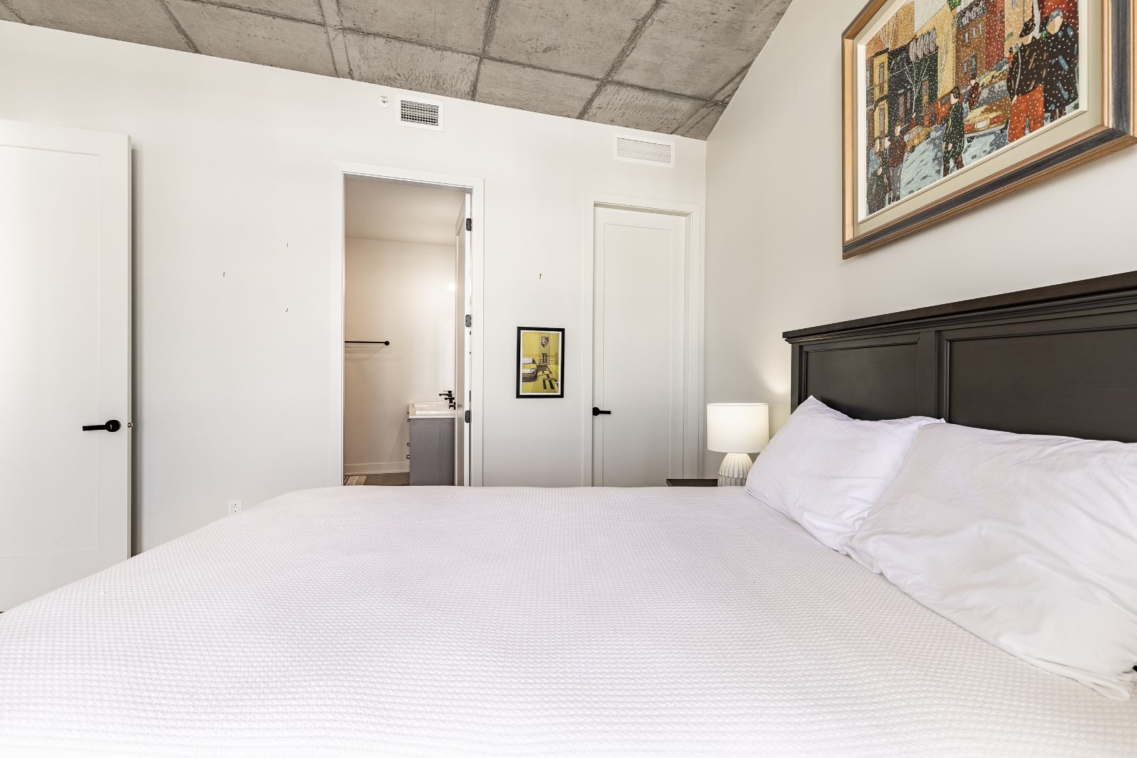 Second bedroom with bed and framed artwork