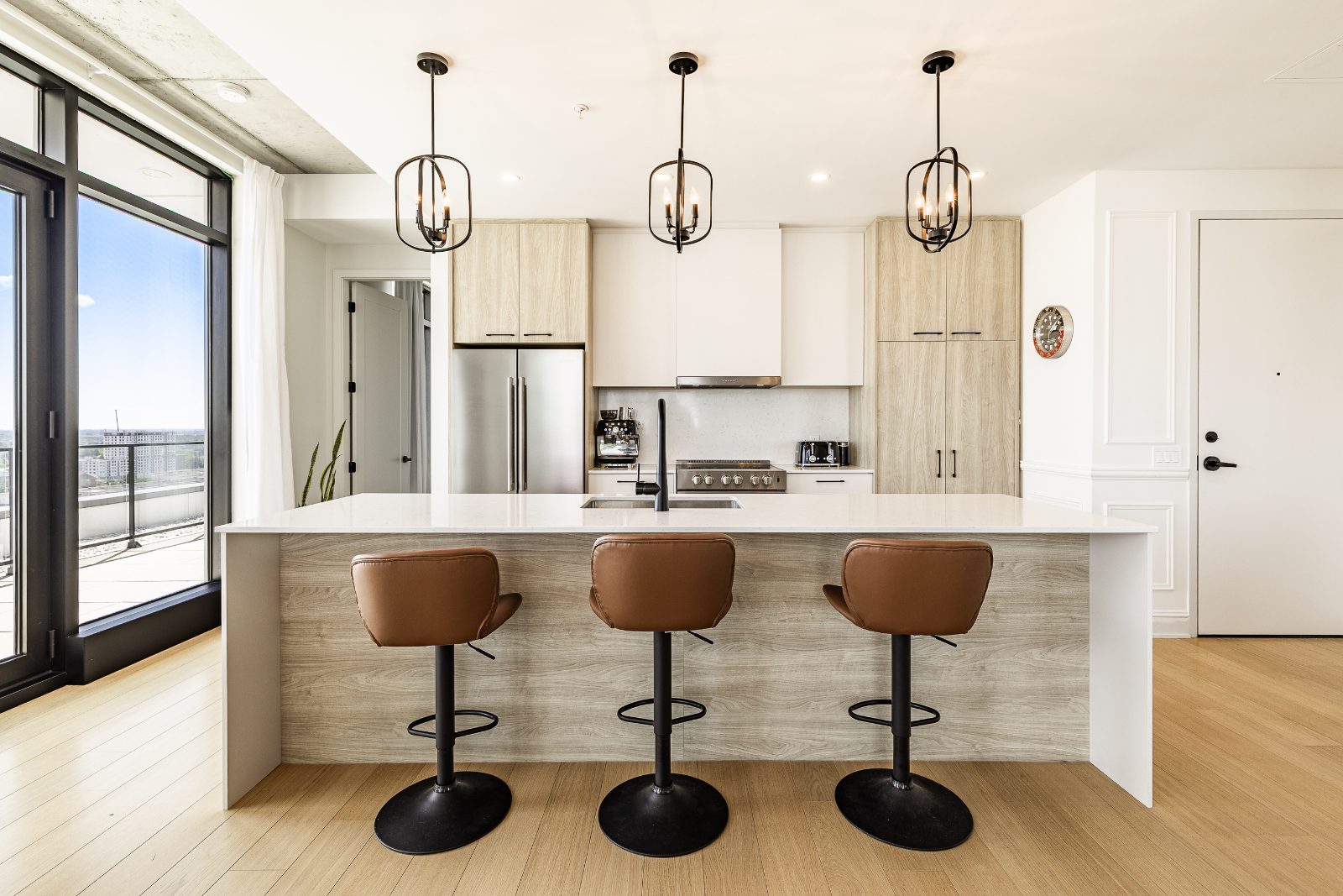 Kitchen island with leather stools and full-height cabinets