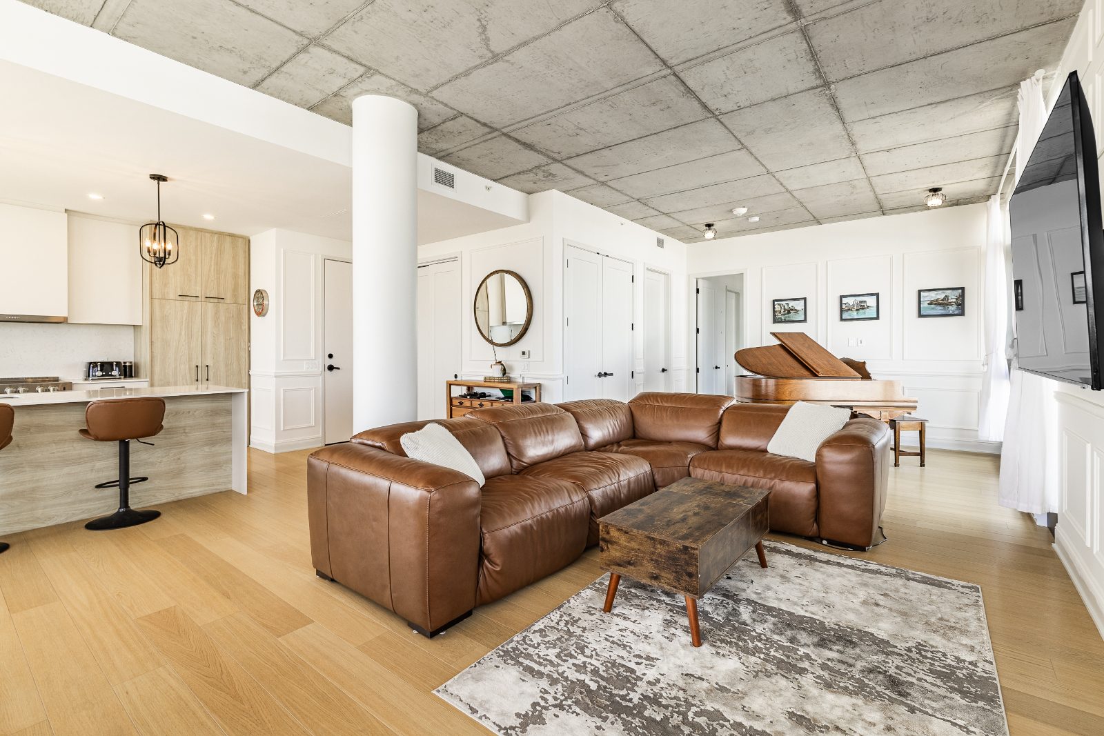 Bright living room with exposed concrete ceiling, open onto the living area