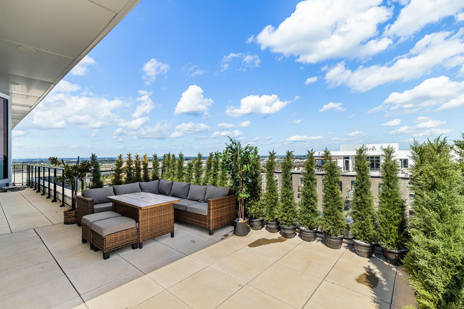 Rattan outdoor lounge on the terrace, lined with greenery